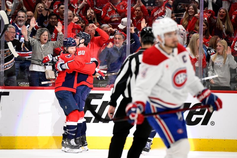 Le défenseur des Capitals de Washington Jakob Chychrun, à gauche, célèbre son but avec l'ailier gauche Pierre-Luc Dubois (80) alors que le centre des Canadiens de Montréal Nick Suzuki (14) patine, à droite, lors de la première période du match 5 d'une série éliminatoire de hockey de première ronde de la LNH, mercredi 30 avril 2025, à Washington.