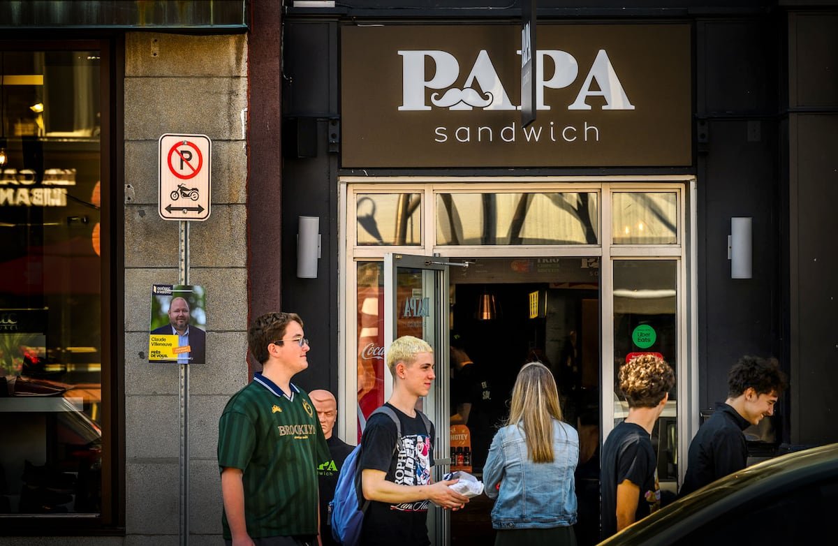 Des clients patientent devant le comptoir de Papa Sandwich, sur la rue Cartier, dans Montcalm.